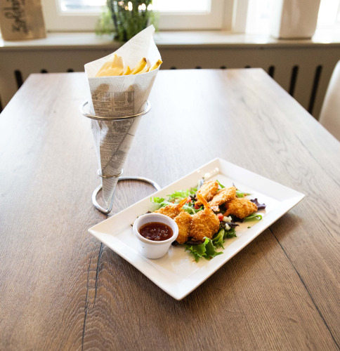 Crispy shrimp with dipping sauce and fries served on a wooden table at Recreatiepark het Esmeer, Gelderland, NL.