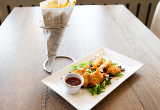 Sprøde rejer med dip og pommes frites serveret på et træbord på Recreatiepark het Esmeer i Gelderland, Holland.