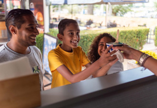 Une famille reçoit une glace à un stand extérieur au Recreatiepark het Esmeer, en Gueldre, Pays-Bas.
