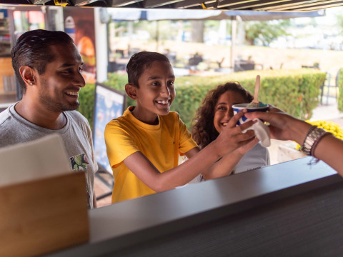 Une famille reçoit une glace à un stand extérieur au Recreatiepark het Esmeer, en Gueldre, Pays-Bas.
