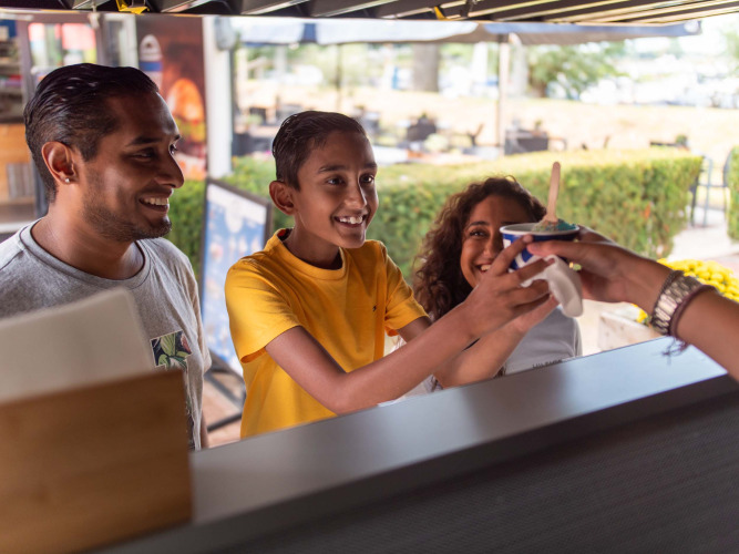 A family receives ice cream at an outdoor stand in Recreatiepark het Esmeer, Gelderland, Netherlands.
