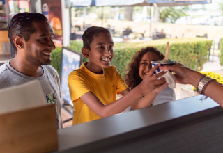 Une famille reçoit une glace à un stand extérieur au Recreatiepark het Esmeer, en Gueldre, Pays-Bas.