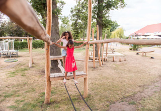 Bambina e adulta giocano insieme su un parco giochi in legno a Résidence Lichtenvoorde, Gelderland, Paesi Bassi.