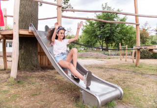 Una ragazza si diverte sullo scivolo a Résidence Lichtenvoorde, un parco vacanze in Gheldria, Paesi Bassi.