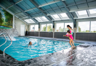 Piscina coperta presso Résidence Lichtenvoorde, bambini felici saltano nell'acqua del parco vacanze.