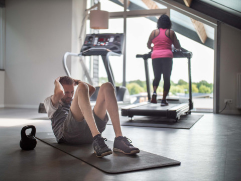 Dos personas haciendo ejercicio en el gimnasio de Résidence Lichtenvoorde en el parque de vacaciones de Gelderland.