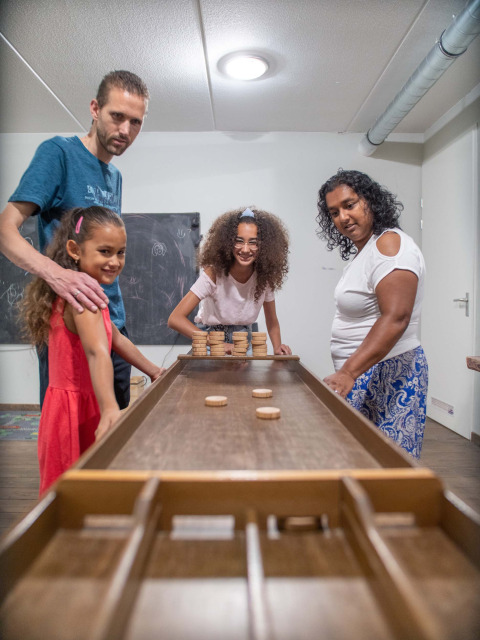 Famiglia che gioca a un gioco da tavolo al Résidence Lichtenvoorde, parco vacanze in Gelderland, Paesi Bassi.