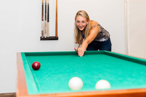 Femme jouant au billard sur une table verte à Résidence Lichtenvoorde, parc de vacances, Gelderland, Pays-Bas.