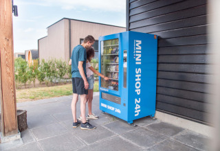Due persone utilizzano un distributore blu 24 ore su 24 presso Résidence Lichtenvoorde in Gelderland, Paesi Bassi.