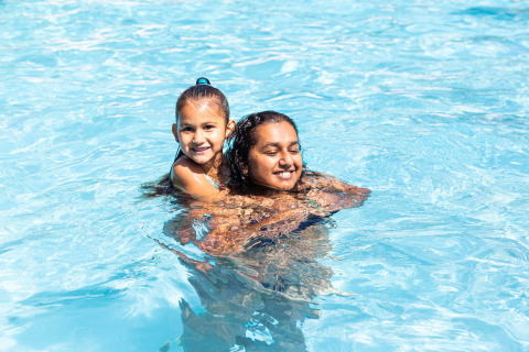 Zwei Kinder spielen und lächeln im Pool im Ferienpark Résidence de Leuvert in Nordbrabant, Niederlande.