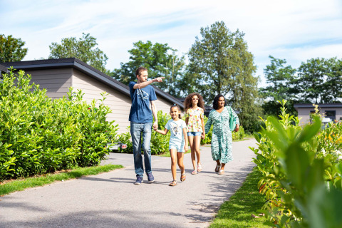 Een gezin loopt op een pad omringd door groen op het vakantiepark Résidence de Leuvert in Noord-Brabant.