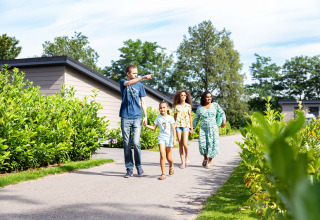 Eine Familie spaziert auf einem Weg in der Résidence de Leuvert, einem Ferienpark in Noord-Brabant, Niederlande.