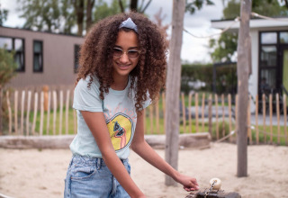 Meisje speelt aan een waterbaan op de speelplaats van Résidence de Leuvert vakantiepark, Noord-Brabant, Nederland.