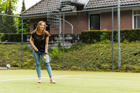 Frau spielt Tennis in Freizeitkleidung auf einem Platz bei Landgoed de Scheleberg, Gelderland, Niederlande.