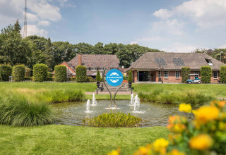 Scenic view of Landgoed de Scheleberg holiday park in Gelderland, Netherlands, featuring fountain and gardens.