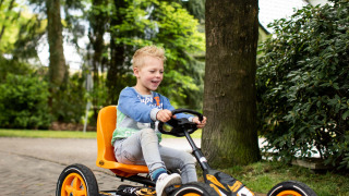 Jongen rijdt op een trapkar bij Landgoed de Scheleberg vakantiepark in Gelderland, Nederland, buiten.