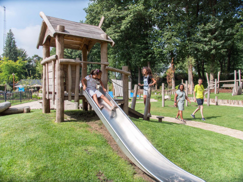 Kinder spielen auf einem Spielplatz mit Rutsche im Landgoed de Scheleberg Ferienpark in Gelderland.