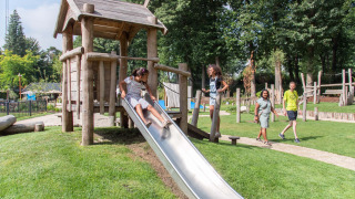 Kinderen spelen op een glijbaan op de speeltuin van Landgoed de Scheleberg vakantiepark in Gelderland.