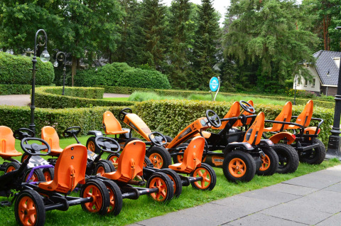 Plusieurs karts à pédales orange sont alignés sur l’herbe à Landgoed de Scheleberg, en Gelderland, Pays-Bas.