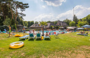 Familier nyder solrige dage ved udendørs pool på Landgoed de Scheleberg feriested i Gelderland, Holland.