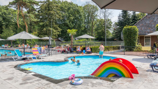 Kindvriendelijk zwembad met regenboogglijbaan bij Landgoed de Scheleberg vakantiepark in Gelderland.