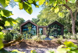 Modern holiday cottage with large windows surrounded by greenery at Résidence Lage Vuursche, Utrecht.