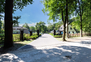 Ingang van Résidence Lage Vuursche vakantiepark in Utrecht, Nederland, met bomen en moderne huizen.