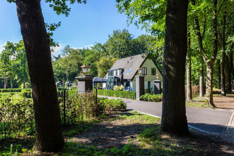 Casa vacanze presso Résidence Lage Vuursche, Utrecht, Paesi Bassi, circondata da alberi e natura verde.