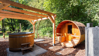 Área de spa al aire libre con sauna de barril y bañera de madera en un parque vacacional de Utrecht.