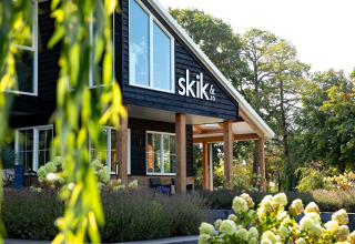 Facade af skik&zo ved Résidence Lichtenvoorde feriepark omgivet af grønne planter i Gelderland, Holland.