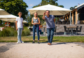 Famiglia gioca a pétanque al parco vacanze Résidence Lichtenvoorde in Gheldria, Paesi Bassi.
