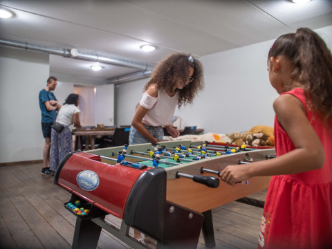 Niños juegan futbolín en la sala de juegos de Résidence Lichtenvoorde, parque vacacional en Gelderland, Países Bajos.
