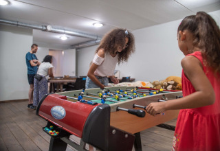 Kinderen spelen tafelvoetbal in het speellokaal van Résidence Lichtenvoorde vakantiepark in Gelderland, Nederland.