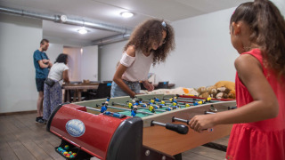 Niños juegan futbolín en la sala de juegos de Résidence Lichtenvoorde, parque vacacional en Gelderland, Países Bajos.