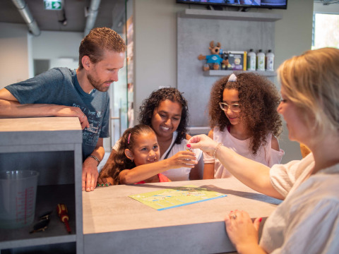 Famiglia al check-in della reception di Résidence Lichtenvoorde, parco vacanze in Gelderland, Paesi Bassi.
