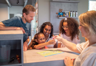 Famiglia al check-in della reception di Résidence Lichtenvoorde, parco vacanze in Gelderland, Paesi Bassi.