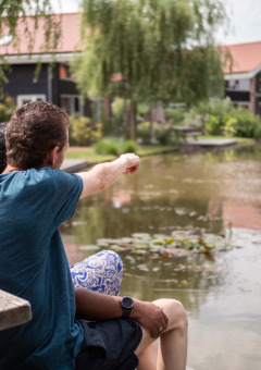 Una pareja sentada junto a un estanque disfruta la vista en Résidence Lichtenvoorde, Gelderland, Países Bajos.