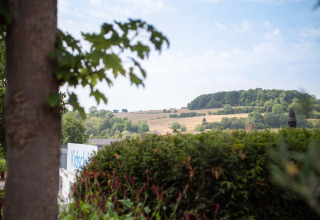 Zicht op het glooiende landschap vanuit Résidence Valkenburg vakantiepark in Limburg, Nederland, met groene velden.