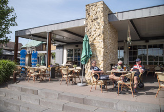 Radfahrer entspannen auf der Terrasse im Ferienpark Résidence Valkenburg in Limburg, Niederlande.