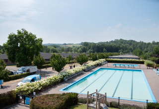 Buitenzwembad aan het vakantiepark Résidence Valkenburg, omringd door groen en heuvels in Limburg, Nederland.