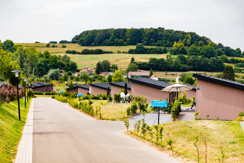 Parque vacacional Résidence Valkenburg en Limburg, Países Bajos, con cabañas y paisajes verdes colinas.