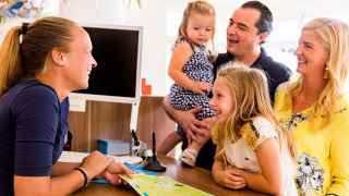 Una familia recibe información en la recepción del parque de vacaciones Résidence Valkenburg en Limburg, Países Bajos.