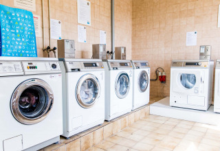 Een heldere wasruimte met meerdere wasmachines bij Résidence Valkenburg, Limburg, Nederland.