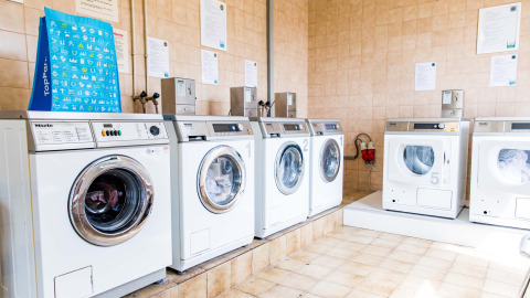 Een heldere wasruimte met meerdere wasmachines bij Résidence Valkenburg, Limburg, Nederland.