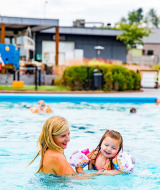 Mutter und Tochter genießen den Pool im Ferienpark Résidence Valkenburg in Limburg, Niederlande, bei Sonne.