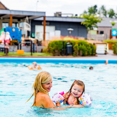 Madre e hija se divierten en la piscina del parque vacacional Résidence Valkenburg en Limburgo, Países Bajos.