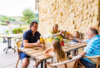 Familie genießt gemeinsam Getränke auf der Terrasse im Ferienpark Résidence Valkenburg in Limburg, Niederlande.