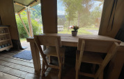 Indvendigt billede af safari-telt på Camping du Rivage i Luxembourg, træbord med stole og udsigt udenfor.