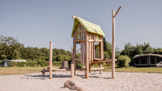 Houten speelhuis op zand, een hoogtepunt van Camping de Bovenberg in Overijssel, Nederland.