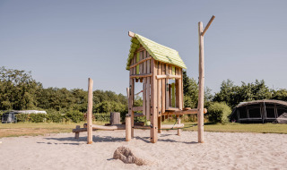 Casa de juegos de madera en arenero, un atractivo del Camping de Bovenberg en Overijssel, Países Bajos.